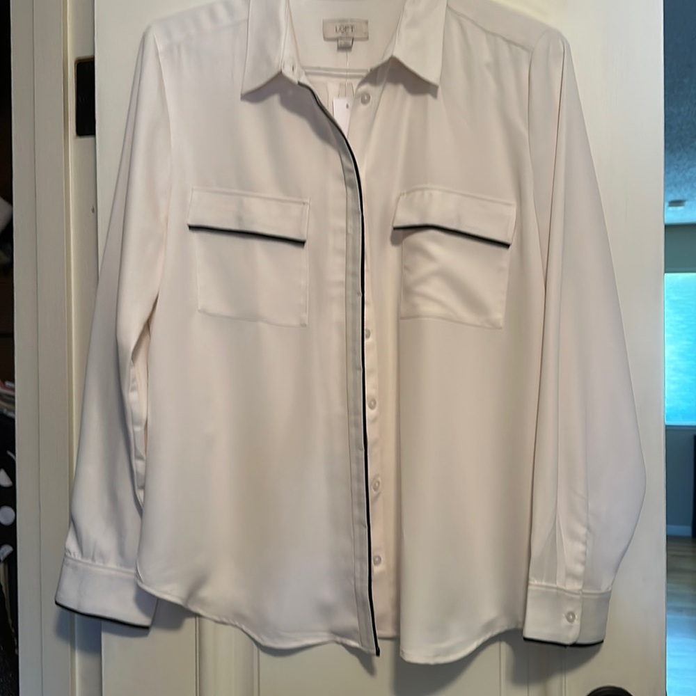 Gorgeous crème colored blouse with black trim.